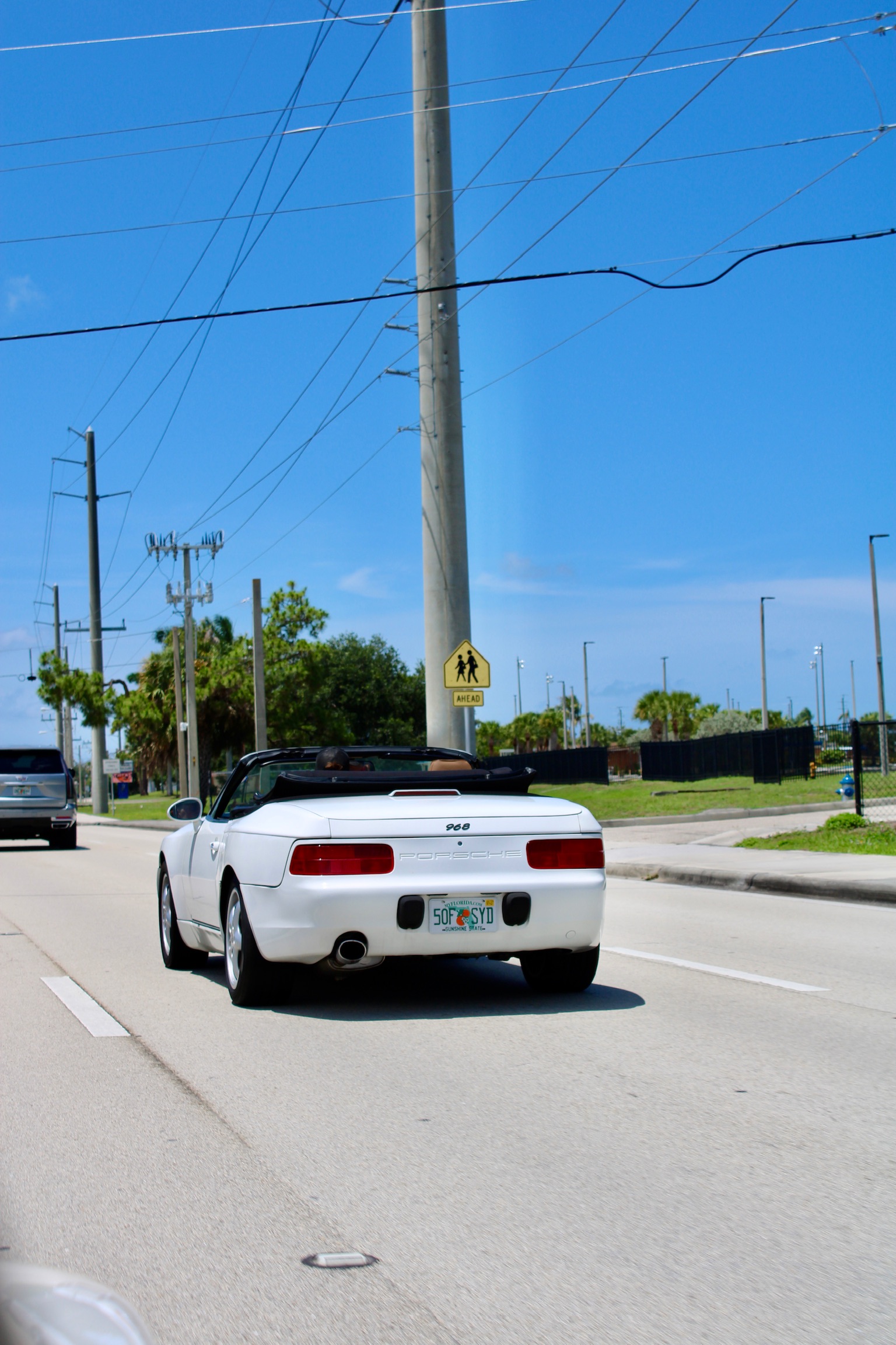 White Porsche 968 driving on road